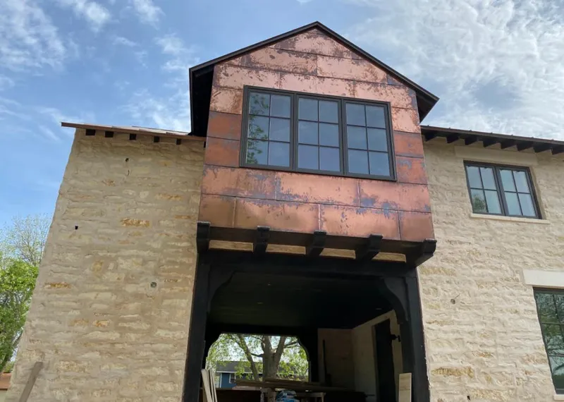 Copper metal panel facade on a stone building for Roof Repair in Atoka